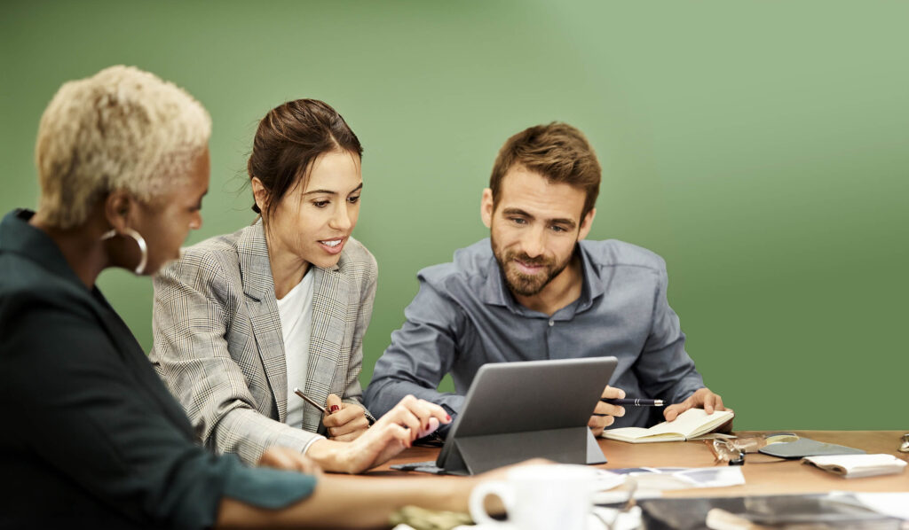 Coworkers discussing over tablet PC in office